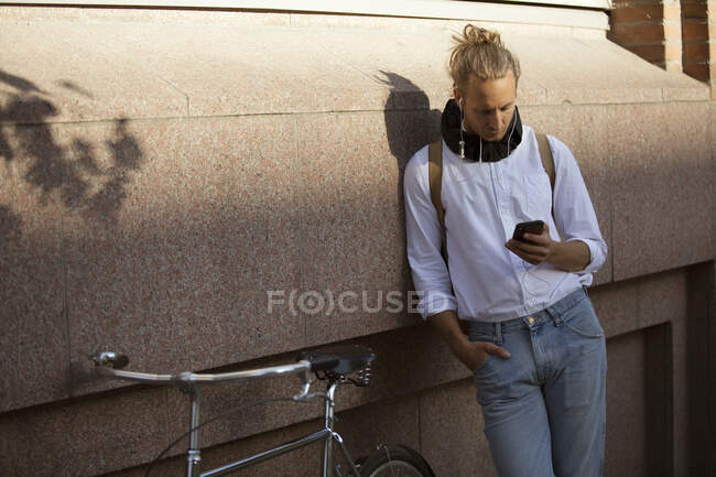 Man listening to music by bicycle — Stock Photo