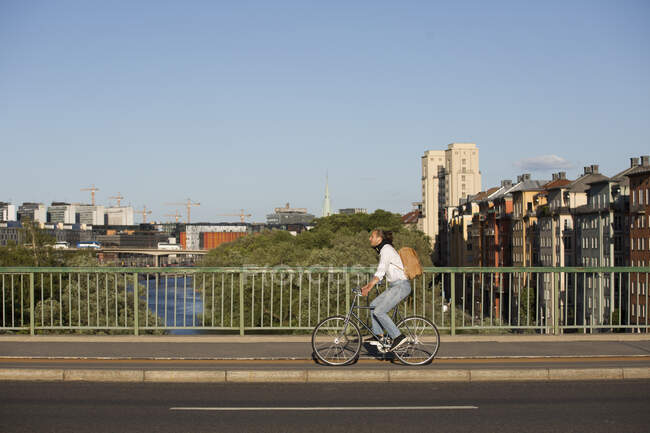 Hombre montar en bicicleta en el puente - foto de stock