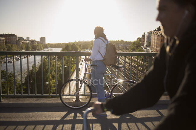 Hombre montar en bicicleta en el puente - foto de stock