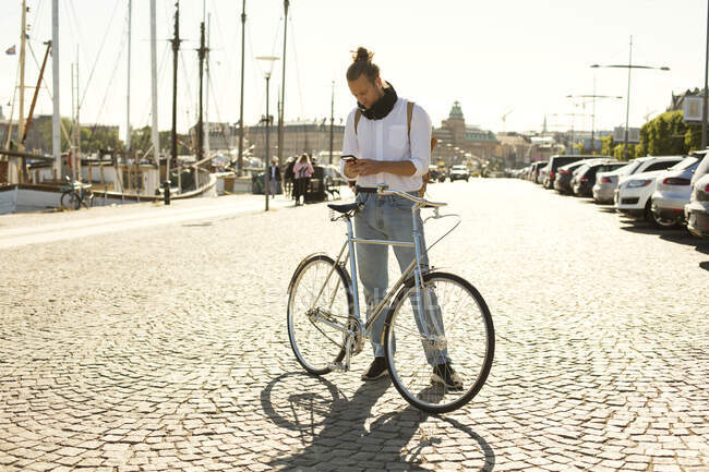 Человек с велосипедом с помощью смартфона — стоковое фото
