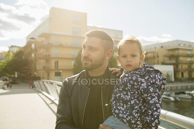 Мужчина держит свою дочь на мосту — стоковое фото