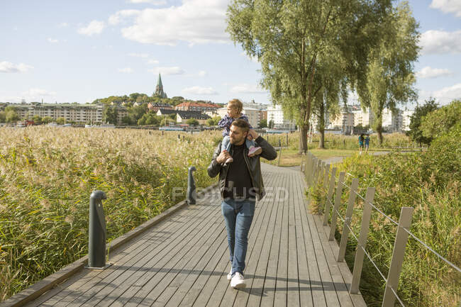 Чоловік дає дочці їздити на поросяті в парку — стокове фото