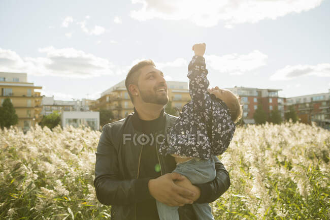 Homme portant sa fille dans le parc — Photo de stock
