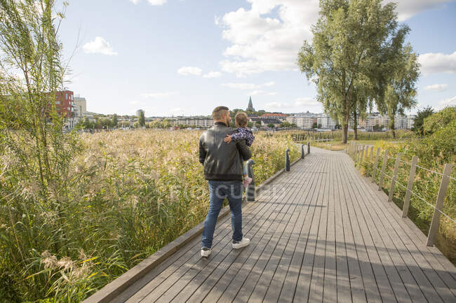 Чоловік, що носить свою дочку в парку — стокове фото
