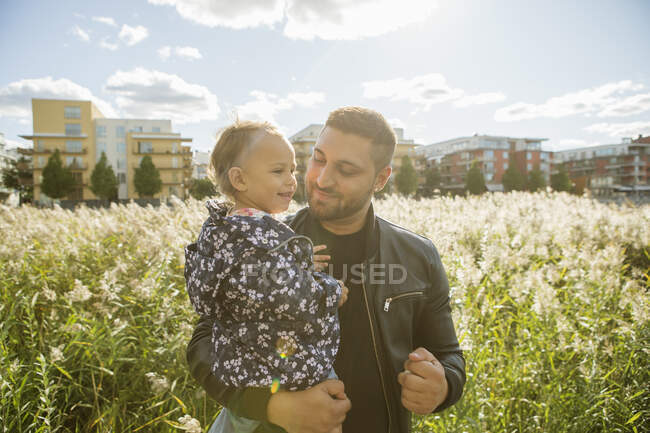 Homme portant sa fille dans le parc — Photo de stock