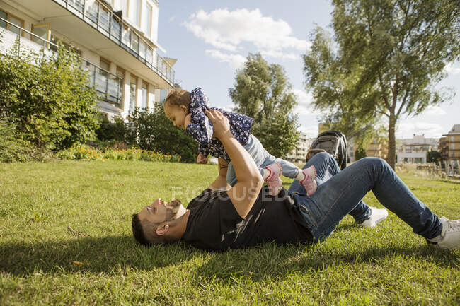Мужчина играет со своей дочерью в парке — стоковое фото