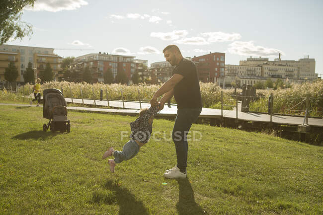 Чоловік грає зі своєю дочкою в парку — стокове фото