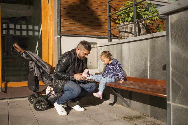 Mann zieht Schuh seiner Tochter an — Stockfoto