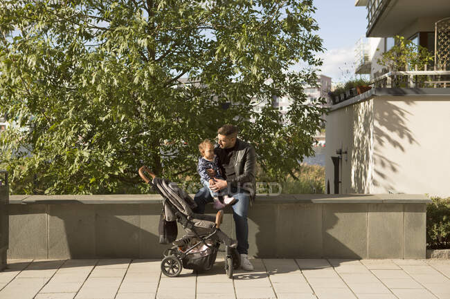 Человек, сидящий со своей дочерью в парке — стоковое фото