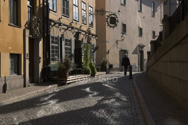 Hombre caminando por la calle en el casco antiguo, Estocolmo - foto de stock