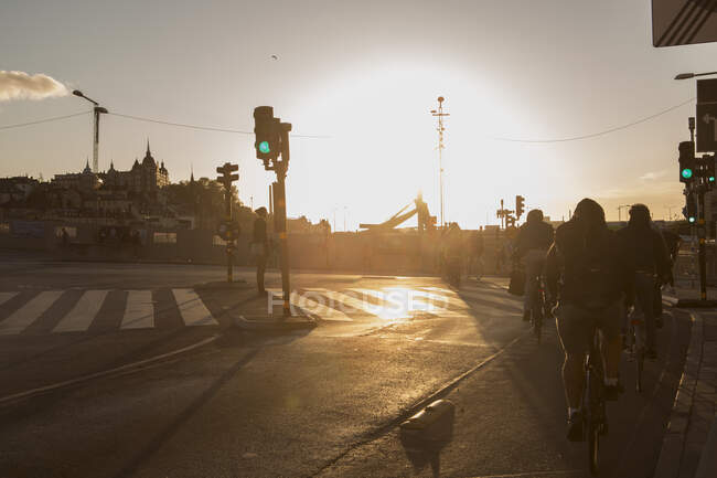 Cyclistes dans la rue pendant le coucher du soleil — Photo de stock