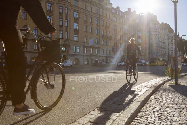 Women riding bicycles on city street — Stock Photo