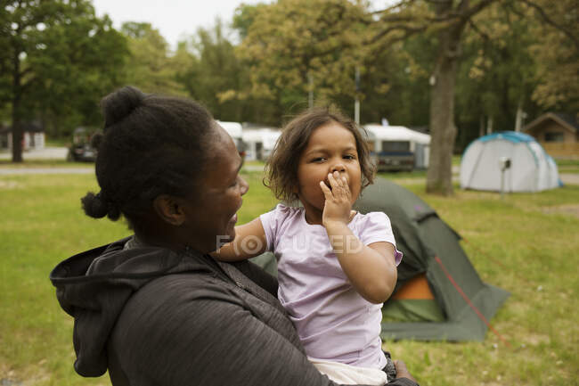 Mother and daughter by tent in field — Stock Photo