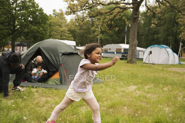 Fille jouer par tente tout en camping — Photo de stock