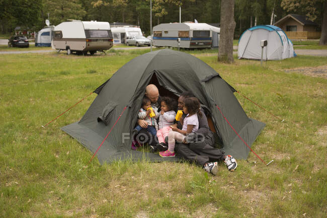 Семья обнимается в палатке во время похода — стоковое фото