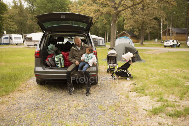 Padre e hija sentados en el coche - foto de stock