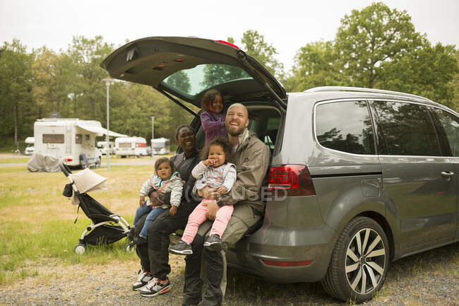 Чоловік і жінка сидять в машині зі своїми дочками — стокове фото