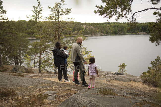 Семья, стоящая у озера во время похода — стоковое фото