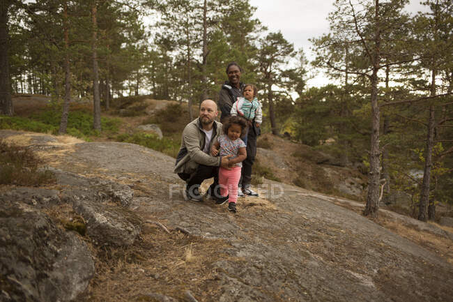 Famille souriante en randonnée en forêt — Photo de stock
