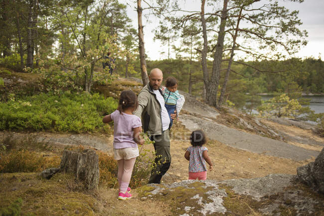 Человек путешествует со своими дочерьми в лесу — стоковое фото