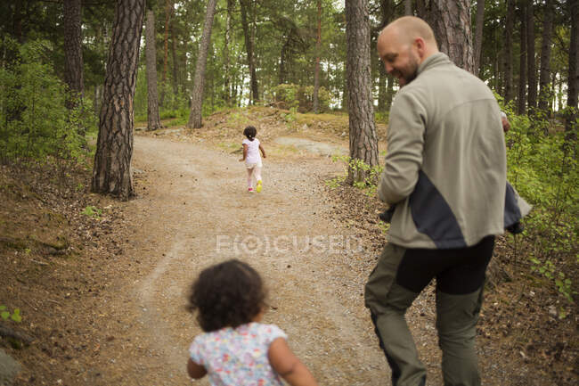 Homem caminhando com suas filhas na floresta — Fotografia de Stock