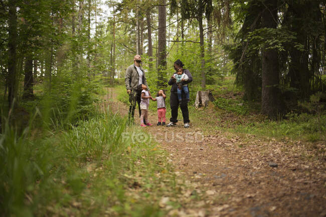 Family standing in forest while hiking — Stock Photo