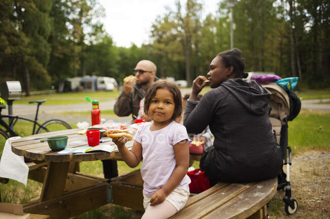 Famiglia mangiare al tavolo da picnic — Foto stock