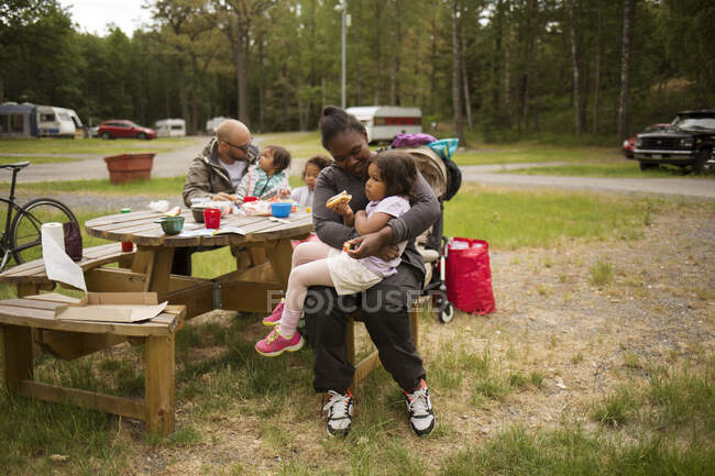 Família comendo na mesa de piquenique — Fotografia de Stock