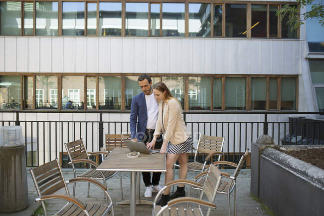 Man and woman working on balcony — Stock Photo