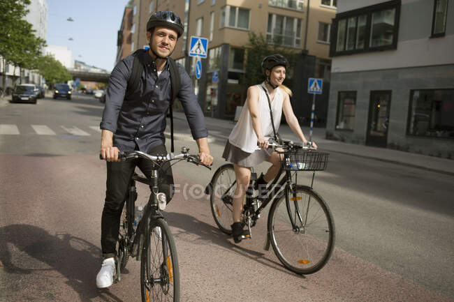 Giovane uomo e donna in bicicletta sulla strada della città — Foto stock