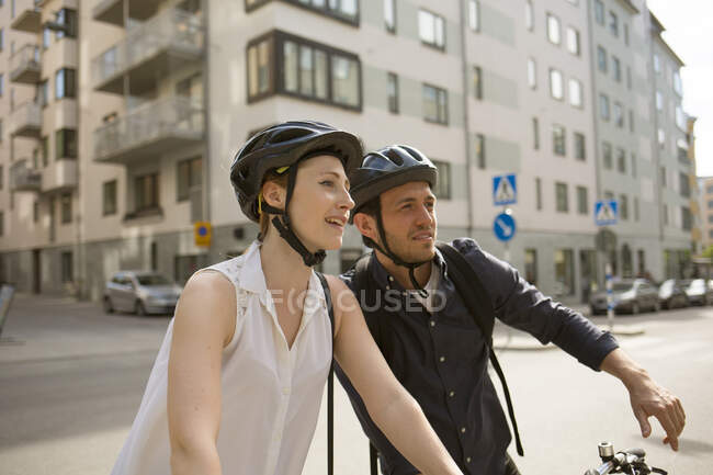 Junger Mann und Frau radeln auf Stadtstraße — Stockfoto
