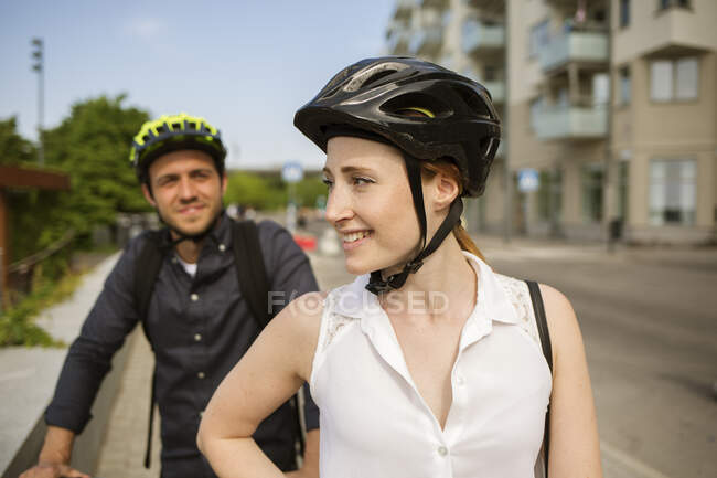 Joven hombre y mujer en cascos de bicicleta - foto de stock