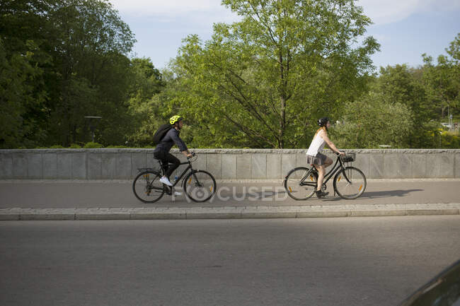 Young man and woman riding bicycles — Stock Photo