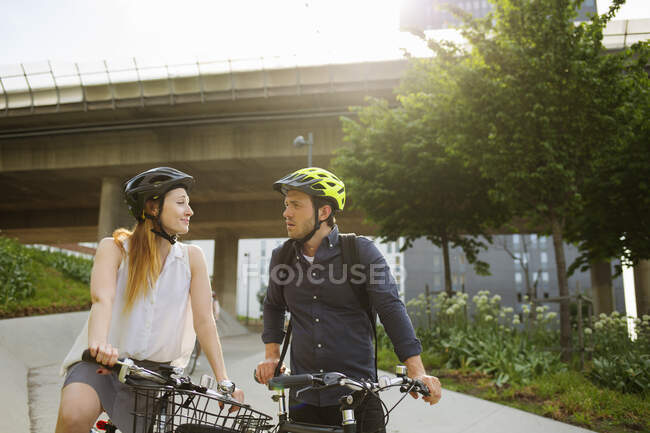Молодой человек и женщина на велосипедах в парке — стоковое фото