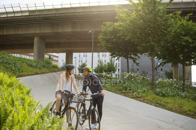 Молодий чоловік і жінка на велосипедах у парку — стокове фото