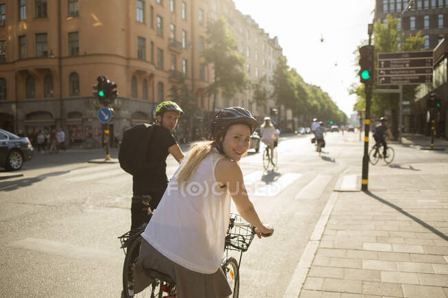 Молодий чоловік і жінка їздять на велосипедах по міській вулиці. — стокове фото