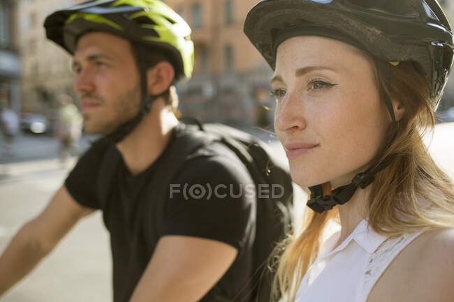Jovem e mulher em capacetes de bicicleta — Fotografia de Stock