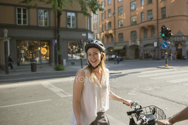 Young woman with bicycle on city street — Stock Photo