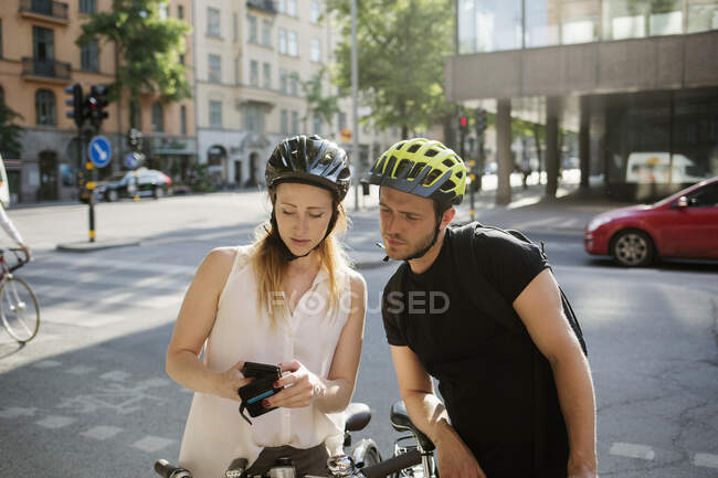 Молодой человек и женщина с помощью смартфона — стоковое фото