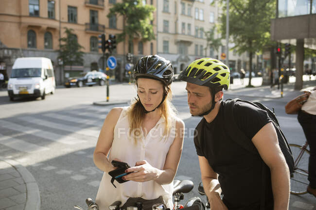 Young man and woman using smartphone — Stock Photo