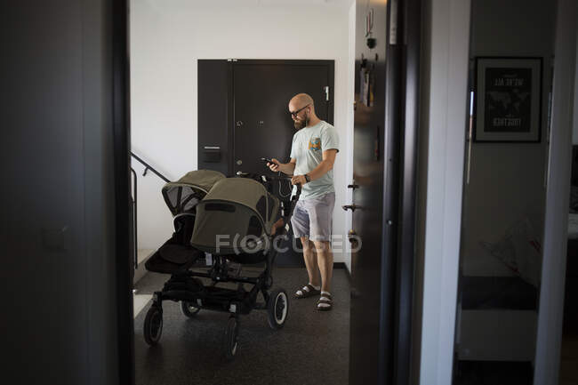 Man listening to music by stroller — Stock Photo