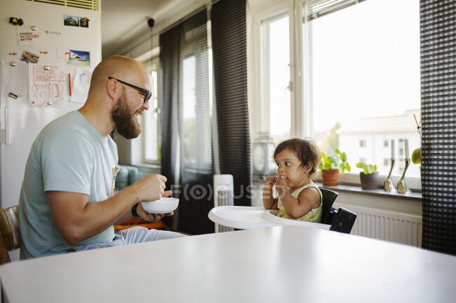 Man feeding his infant daughter — Stock Photo