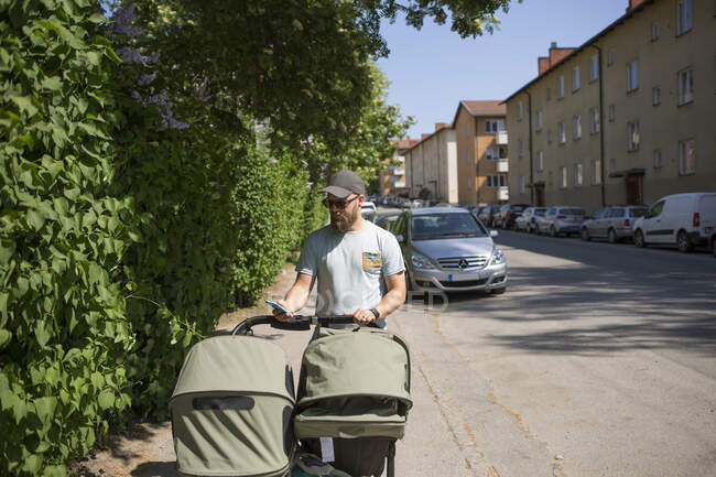 Mann läuft mit Kinderwagen auf Straße — Stockfoto