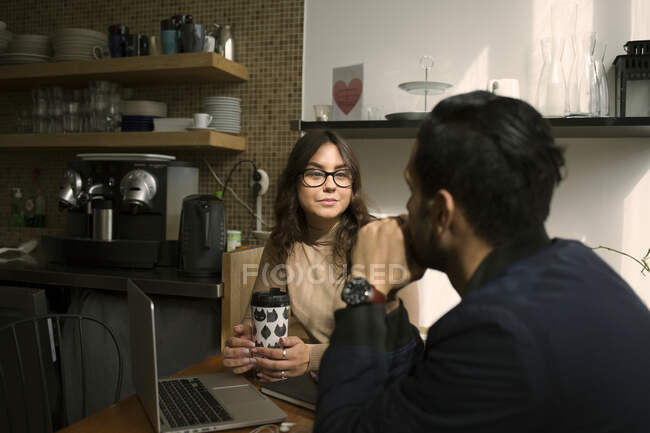 Hombre y mujer hablando en sala de descanso - foto de stock