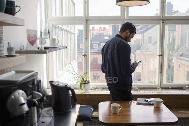 Junger Mann mit Smartphone in Büro-Pausenraum — Stockfoto