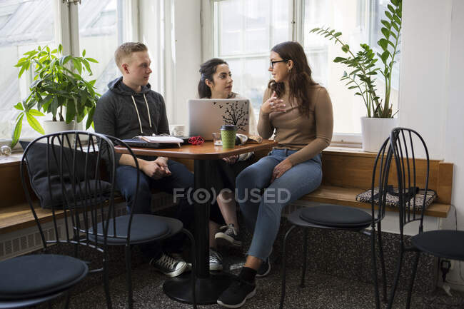 Compañeros de trabajo hablando en la sala de descanso - foto de stock