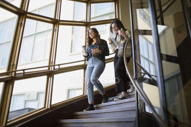 Young women walking on staircase — Stock Photo