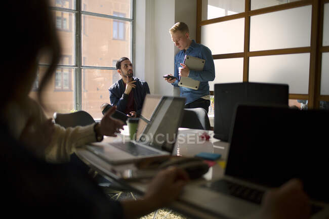 Les jeunes hommes parlent au bureau — Photo de stock