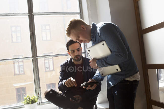 Les jeunes hommes parlent au bureau — Photo de stock