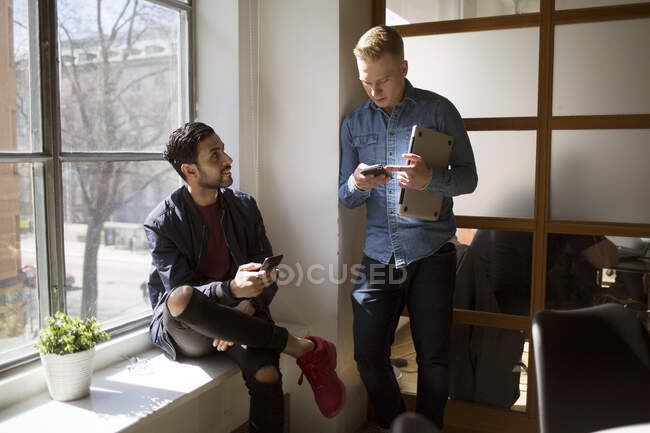 Junge Männer reden im Büro — Stockfoto
